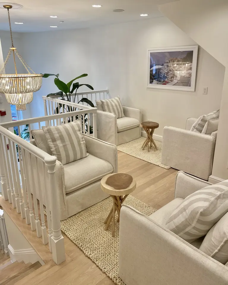 Upstairs lounge seating area at Seaport Medspa North End with armchairs and chandelier