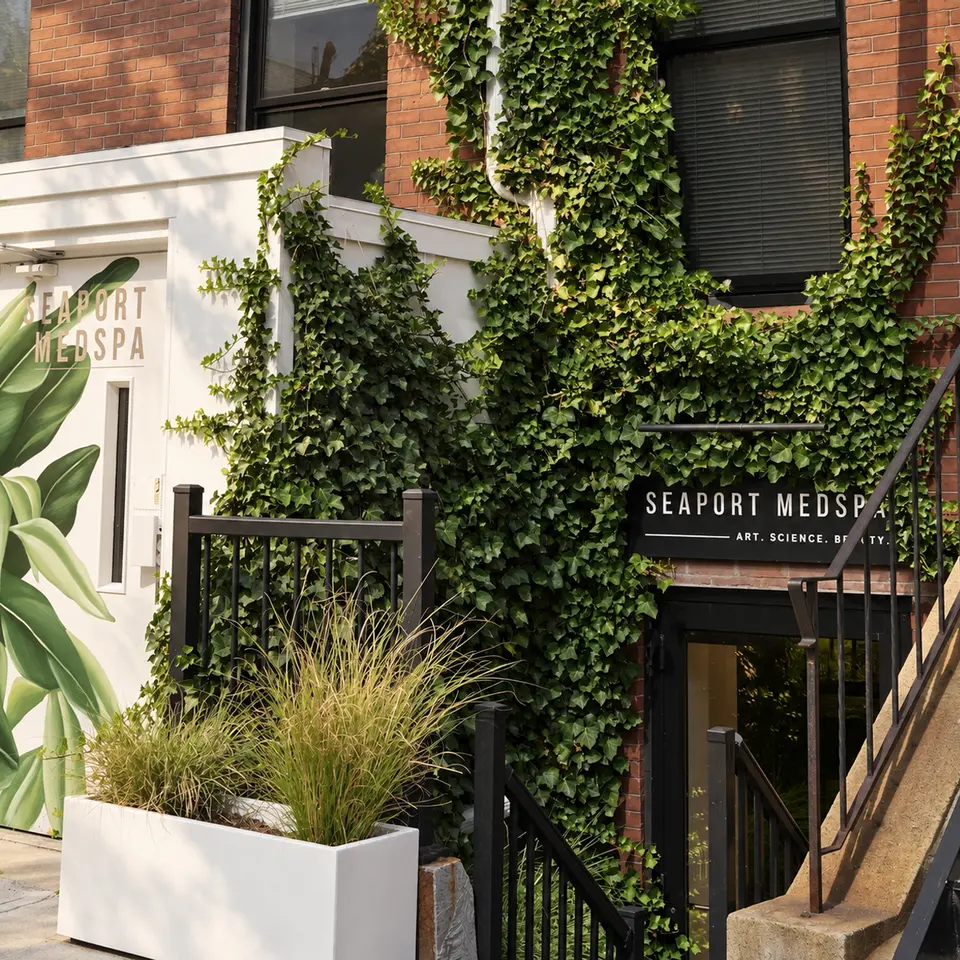 Ivy-covered storefront entrance of Seaport Medspa South Boston with illuminated sign