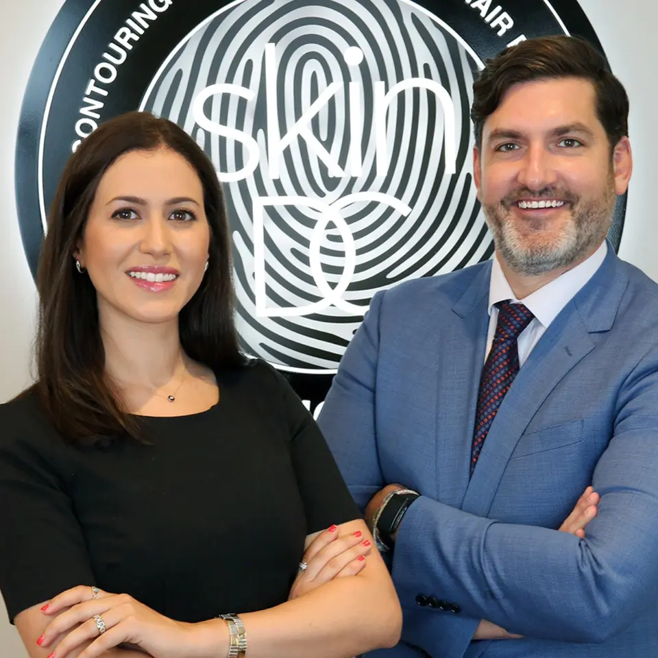 SkinDC dermatologists in front of the practice logo