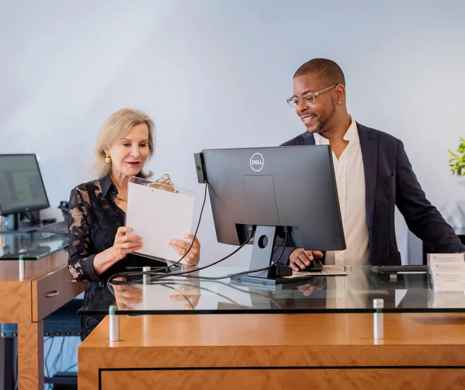 Front desk reception area at SkinHealth Centers with staff checking in a client