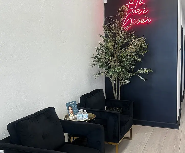 Waiting area at The Skin Agency Glendale with neon 'No Fuzz Given' sign