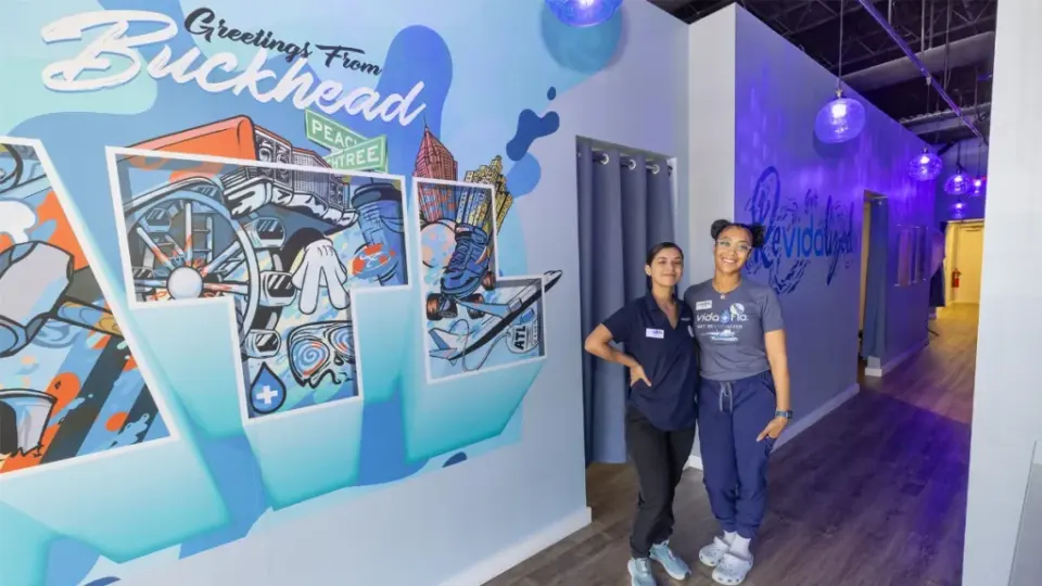 Front desk and hallway mural at Vida Flo Buckhead