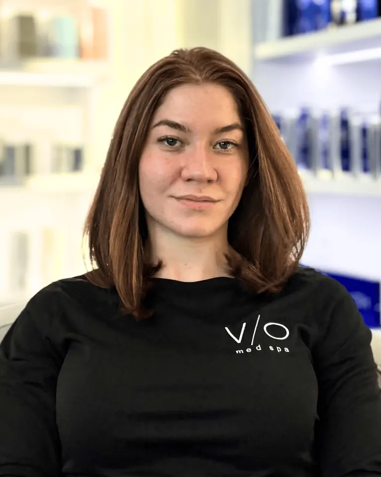Ester Salgado, Esthetician at VIO Med Spa Newton, photographed in the clinic retail/display area