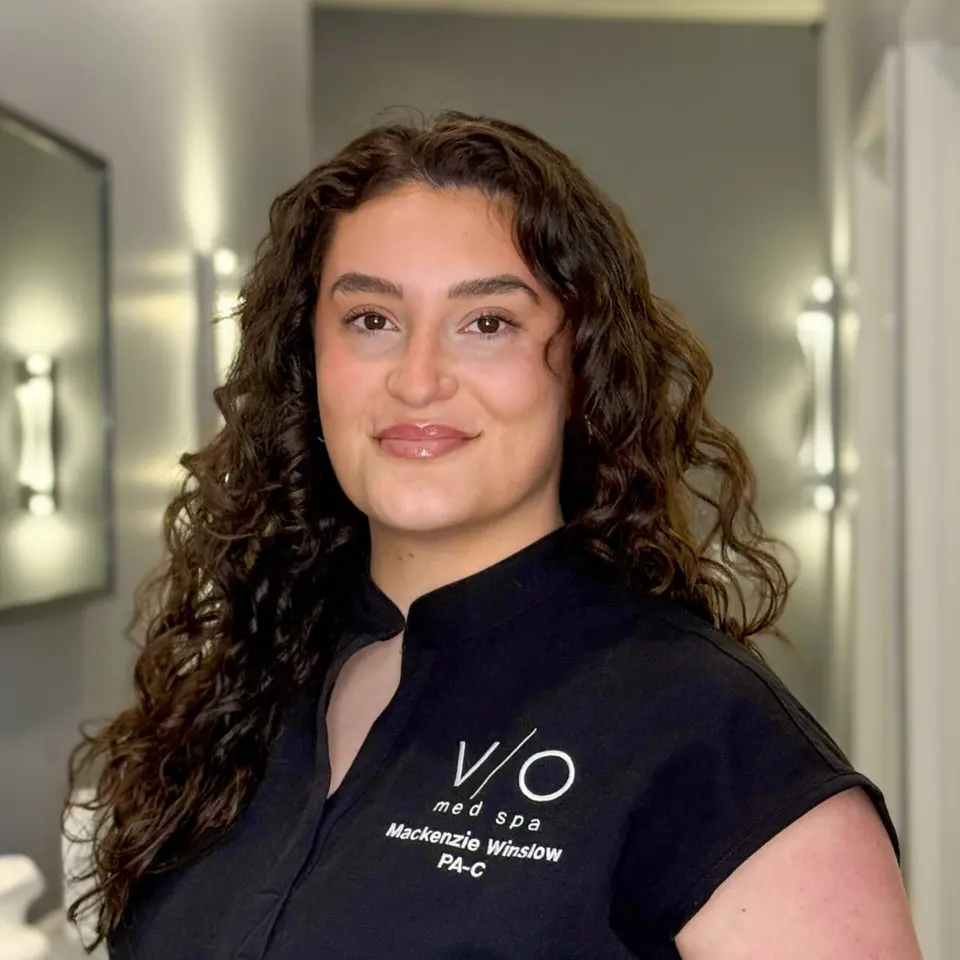 Mackenzie Winslow, PA-C, in the VIO Med Spa South End hallway (name embroidered on uniform)